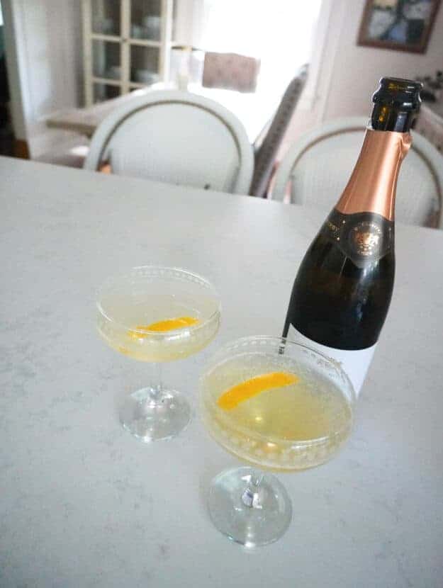 two french 75 cocktails sitting on a counter in a coupe