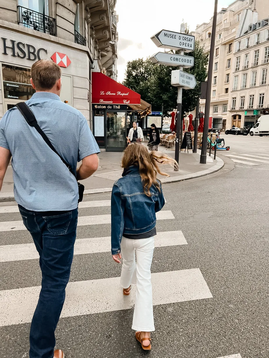 Father and daughter walking across the street in Paris