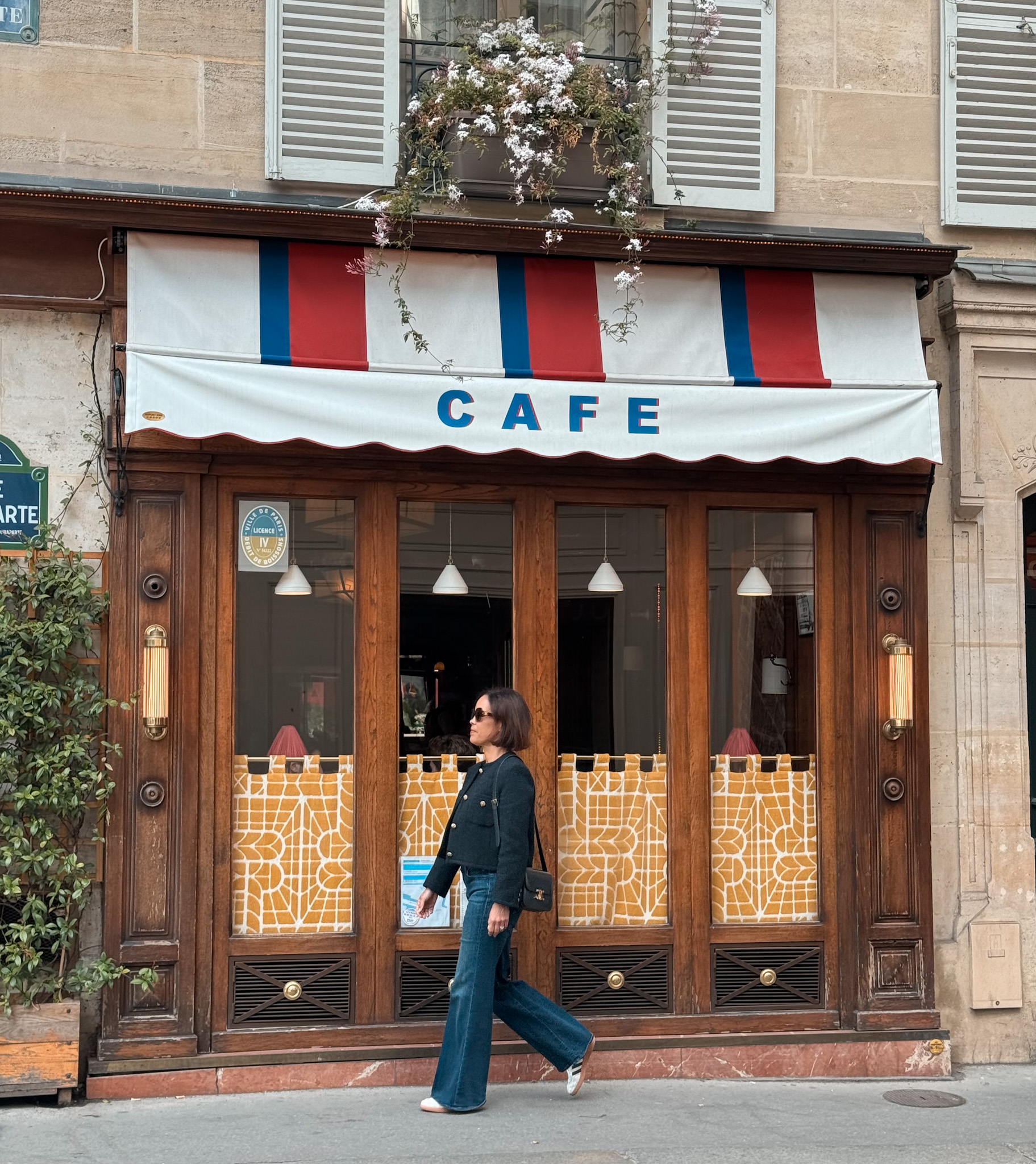 Parisian lifestyle moment walking past a cafƩ as part of everyday French life