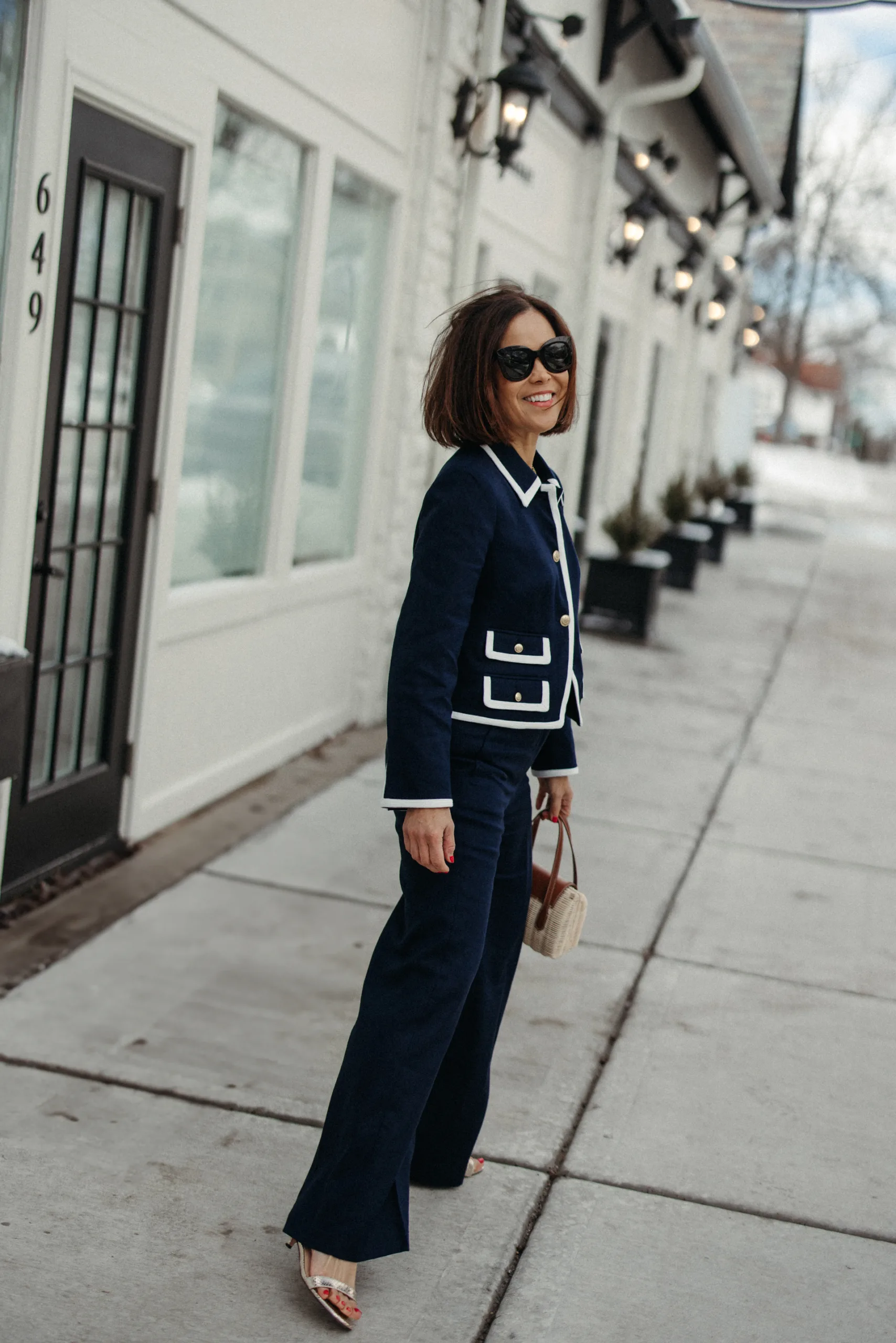 
Woman wearing navy suit jacket and sandals.