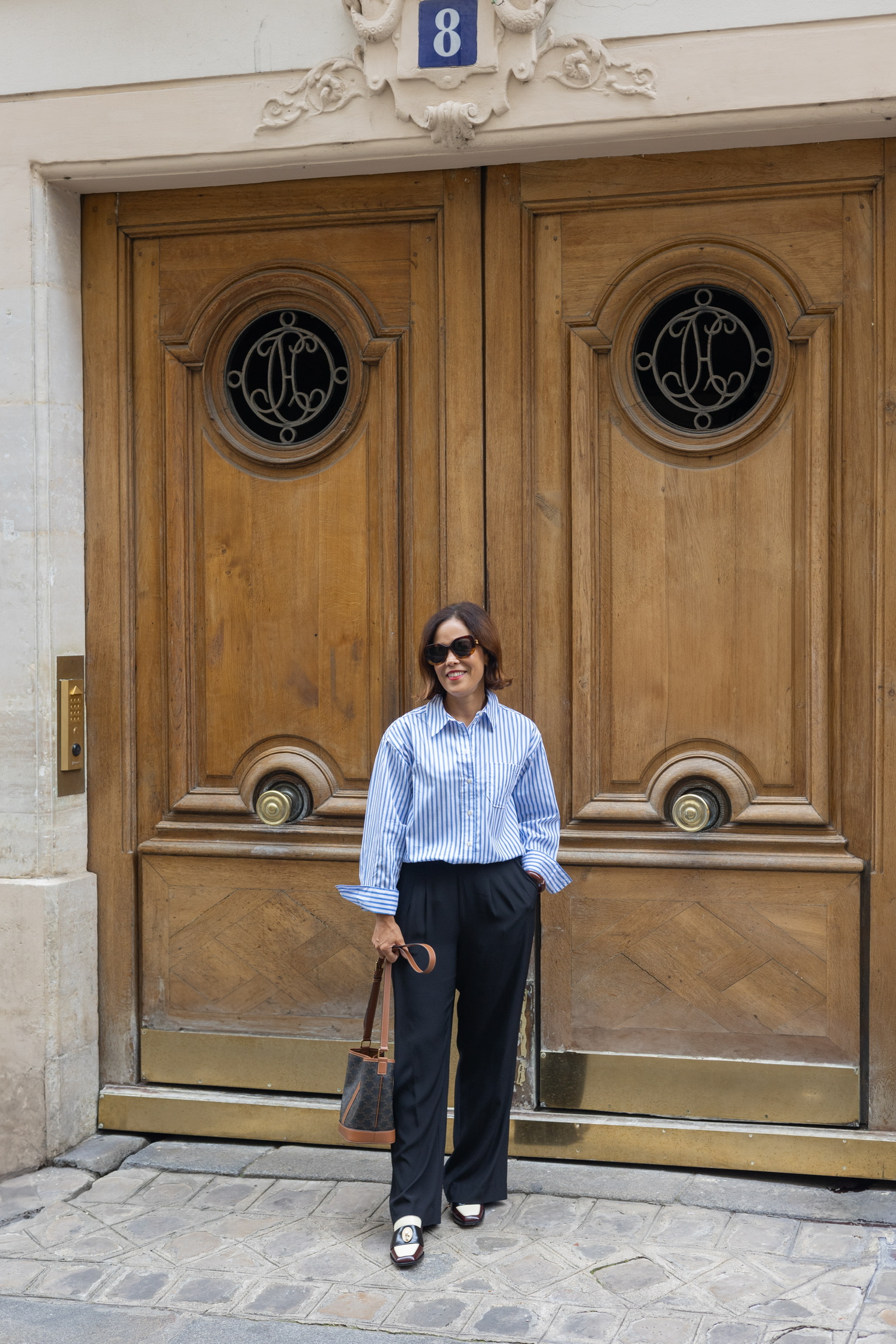 Woman wearing button down blouse in Paris.