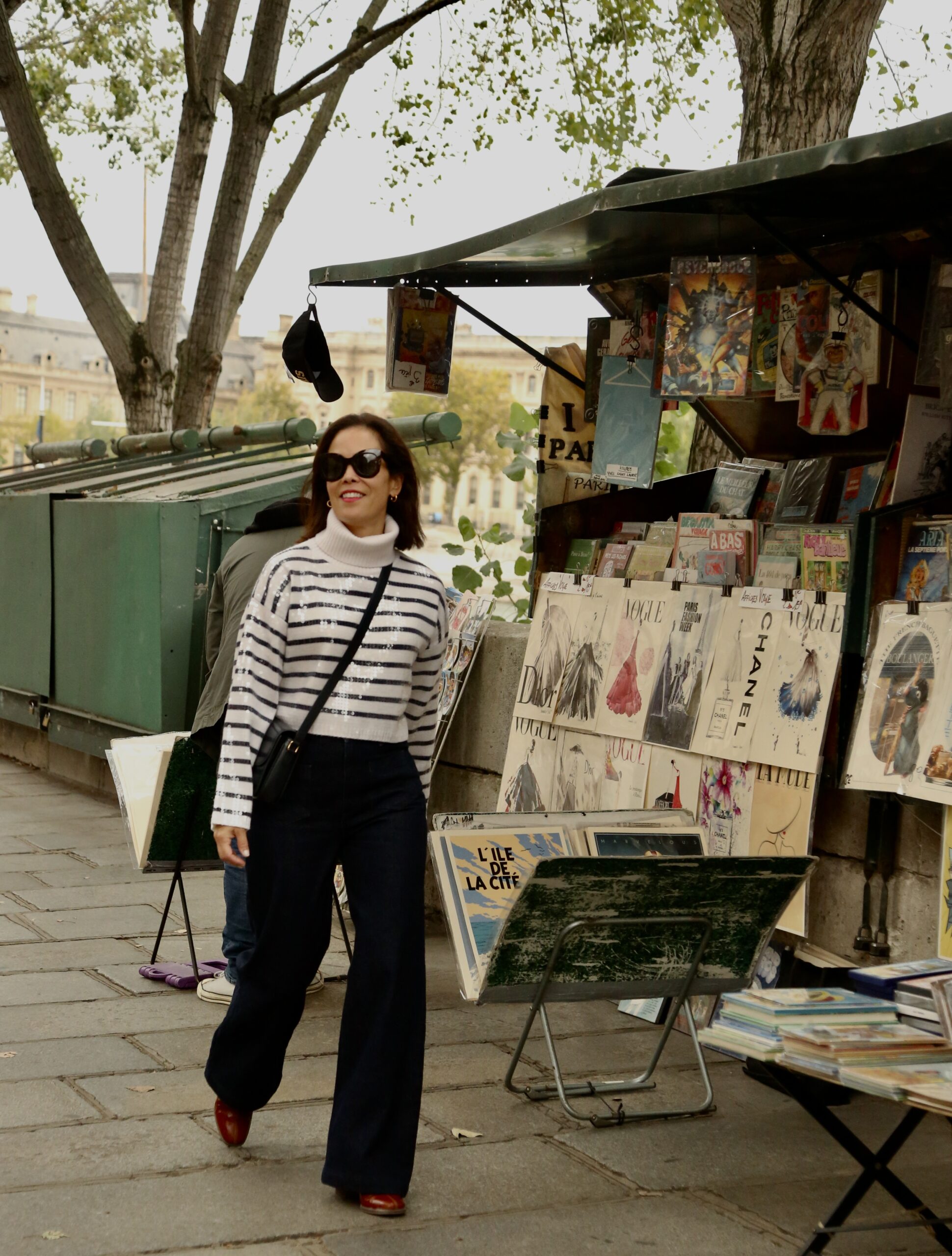 Woman wearing stripe top and denim in Paris walking around.