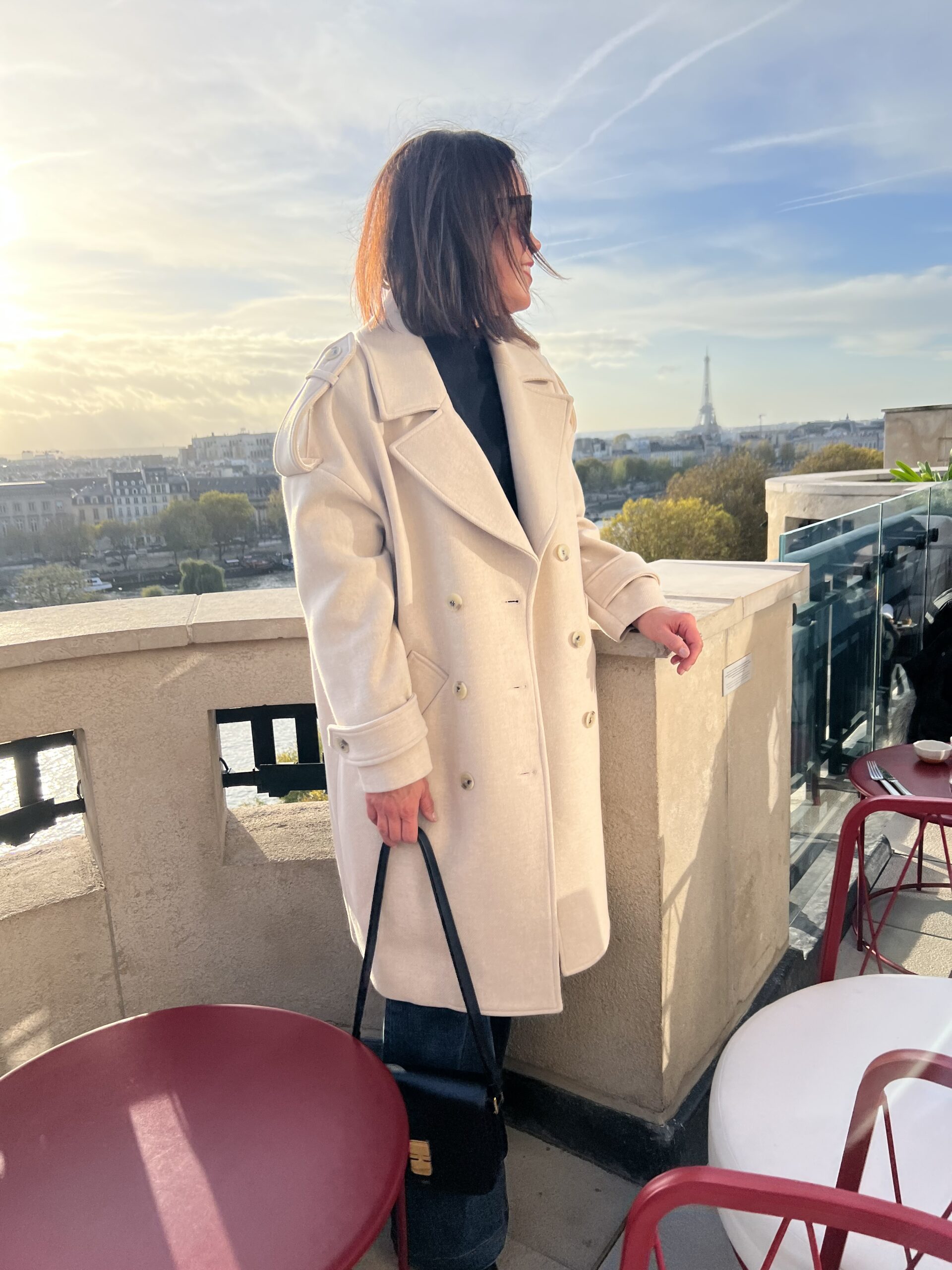 Woman in ivory coat with black bag.