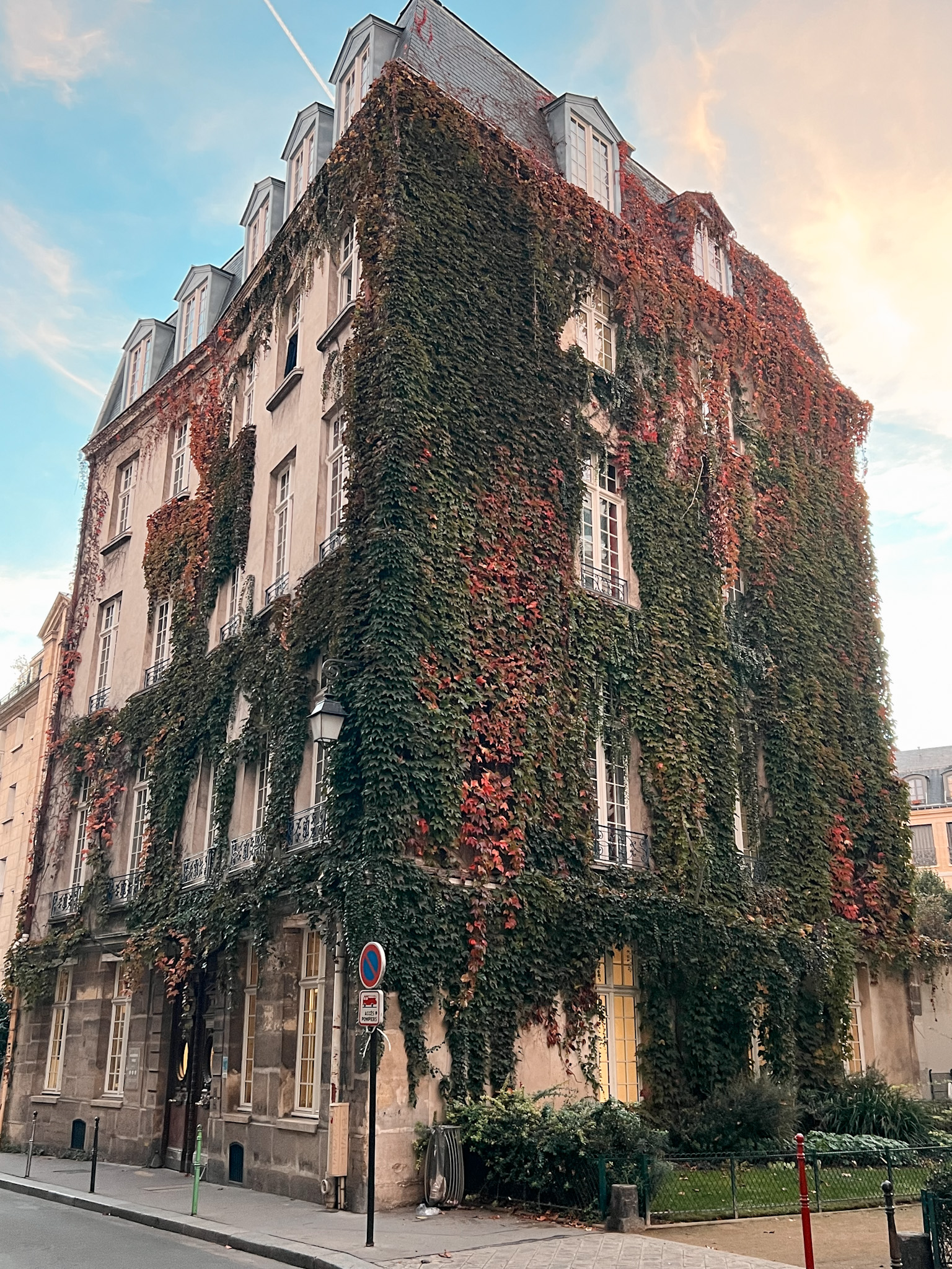 Building with red and green leaves in the Marais in November.