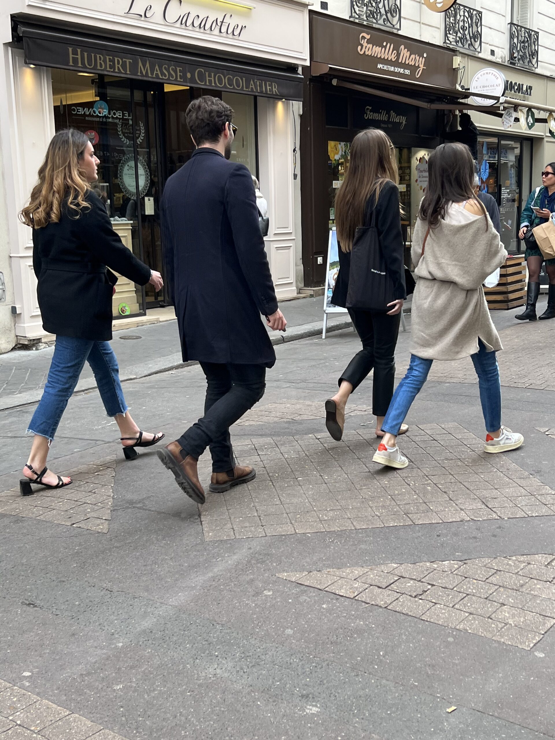 Man walking in Paris with navy coat, pants, and dress shoes.