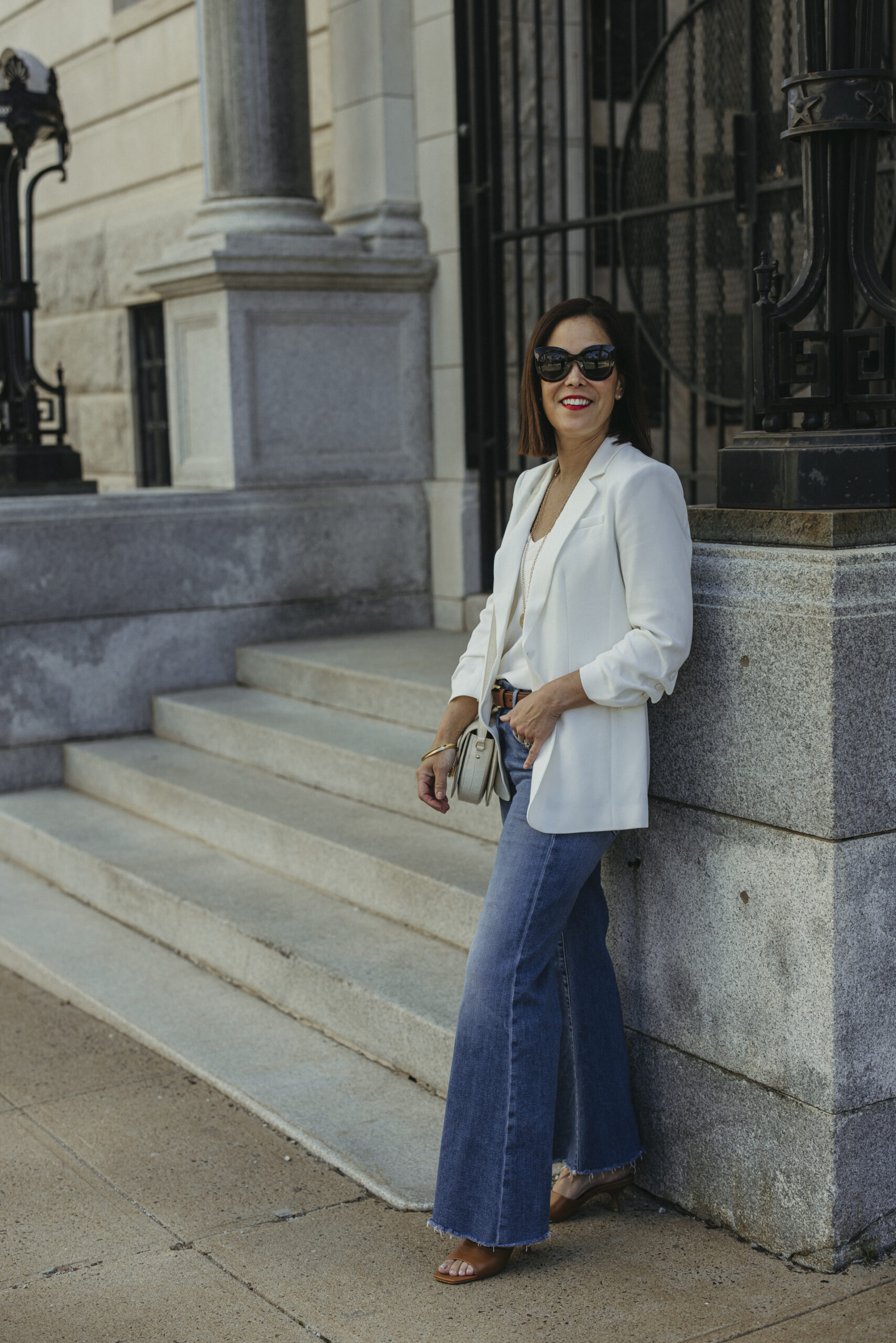 Chic French-inspired spring outfit featuring a white blazer styled with denim and a silk blouse for an elegant Parisian look
