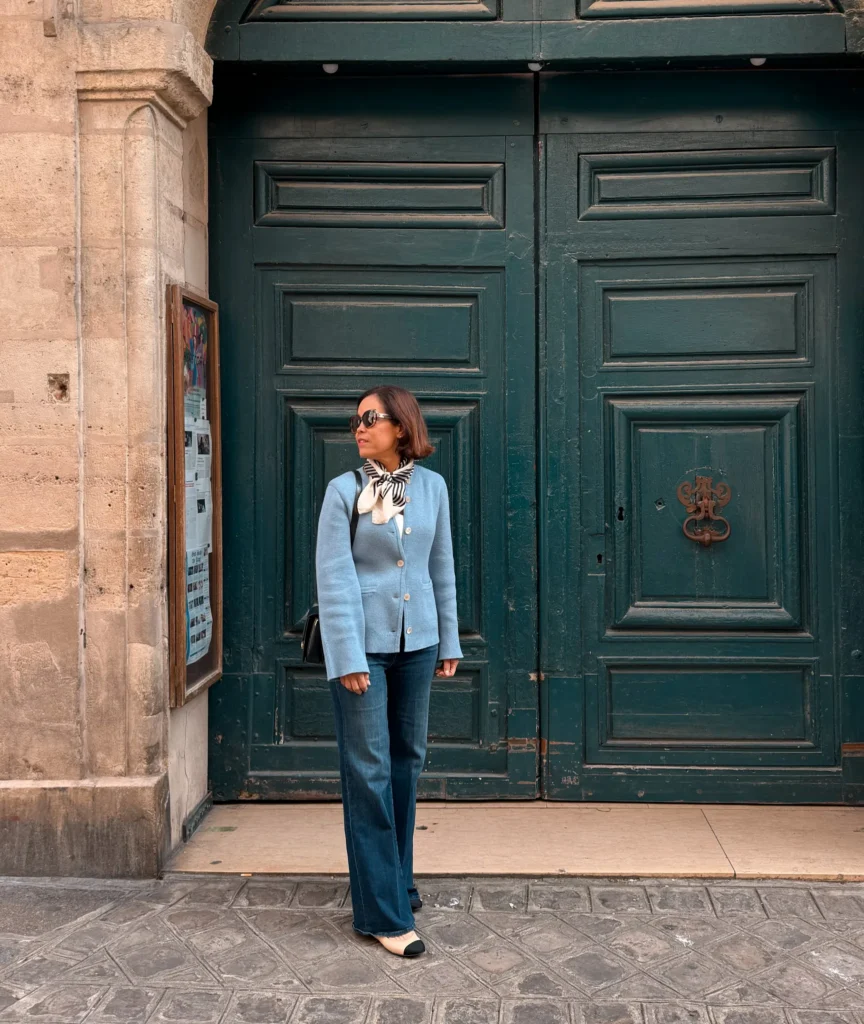 Woman wearing blue cardigan with denim and ballet flats.