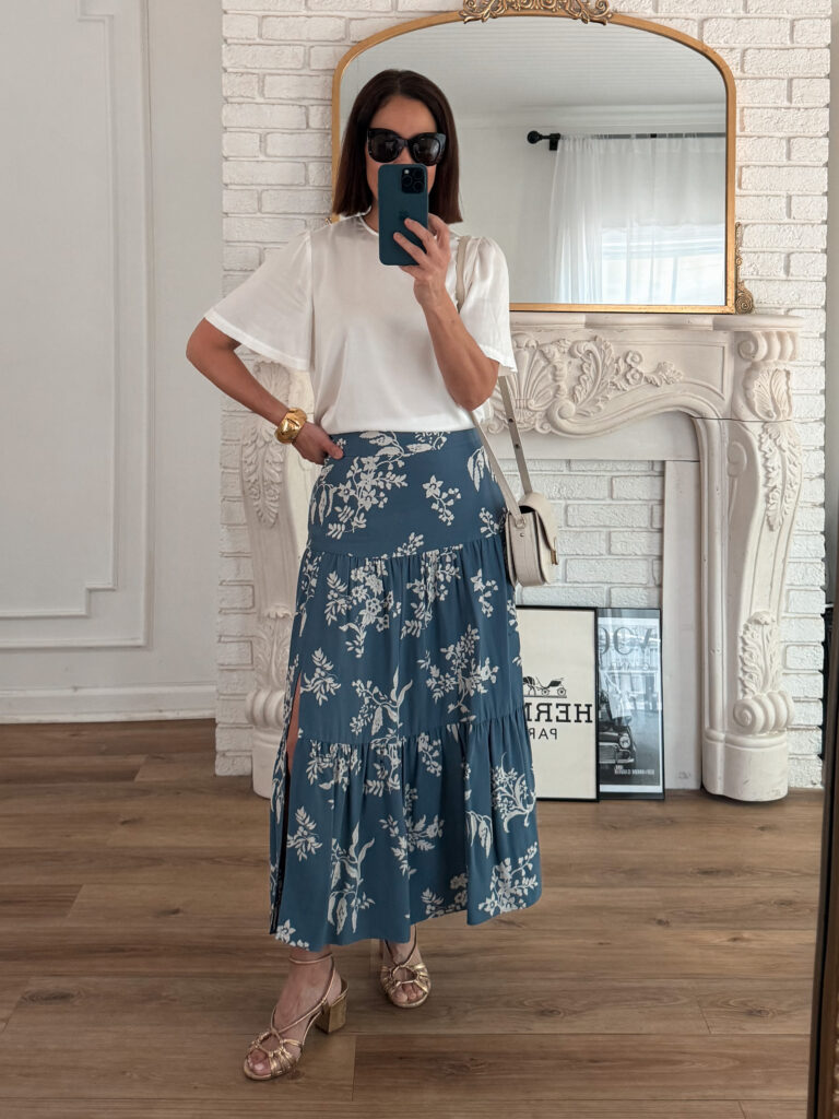Noelani wearing gold strappy sandals with blue floral midi skirt and white top, French girl spring sandal outfit.