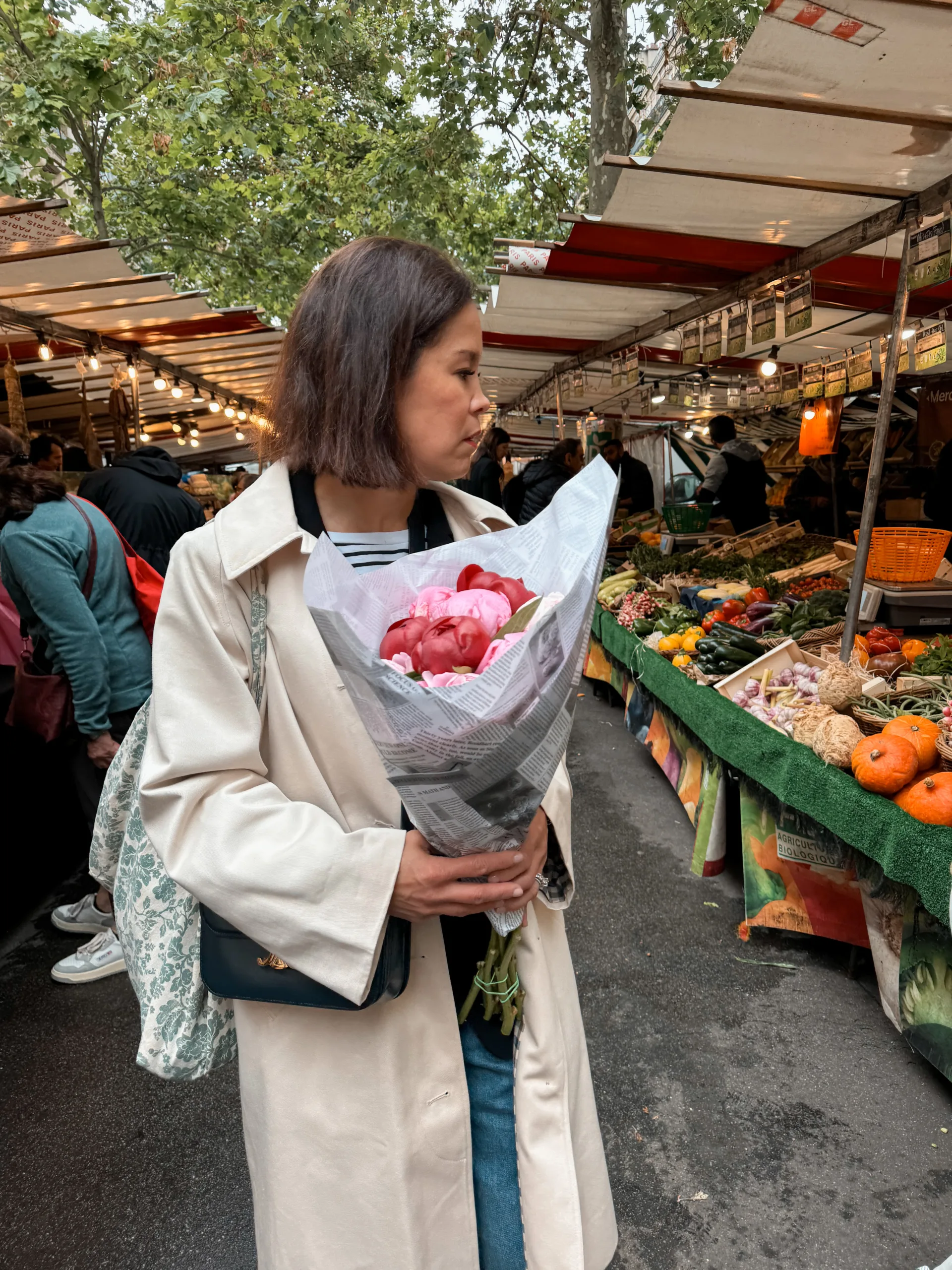 Woman wearing trench coat in June in paris for summer french essentials.