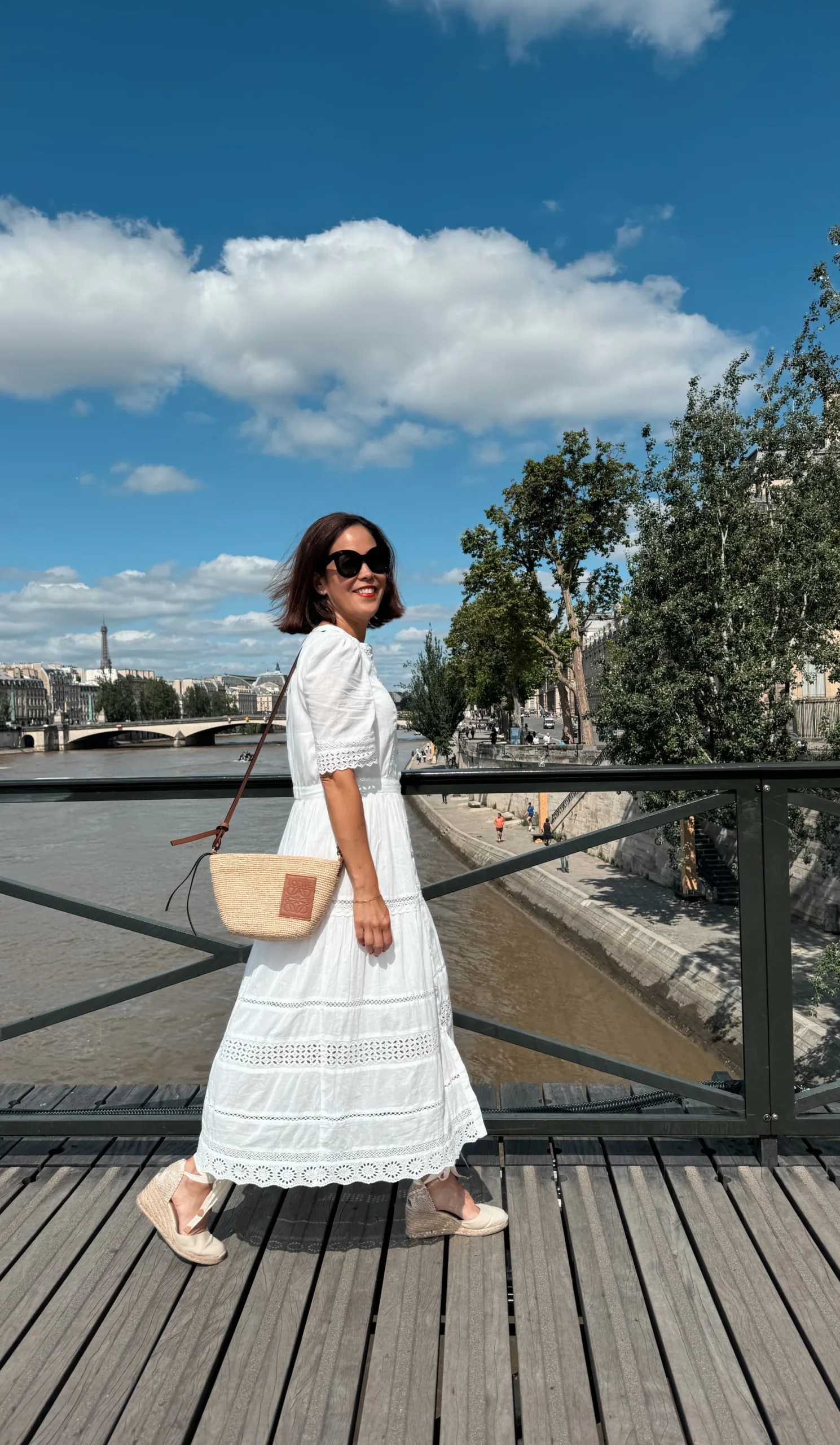 Woman in white dress with espadrilles on Seine river.