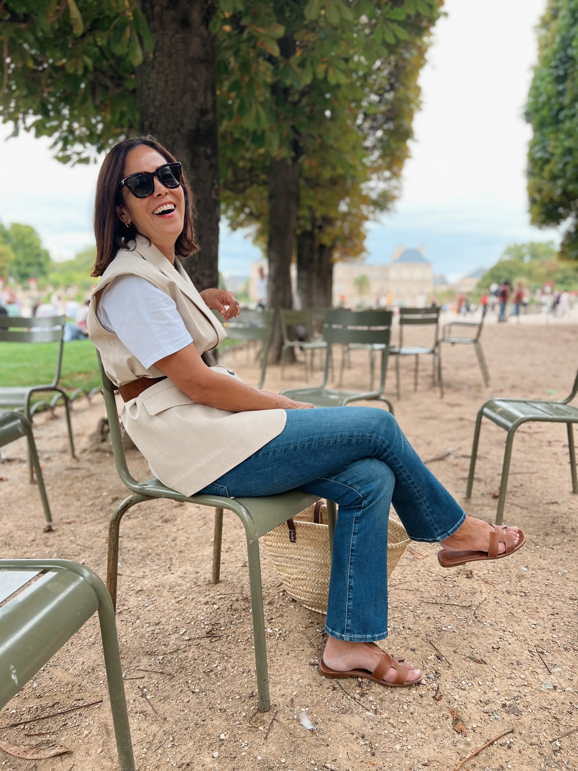 Woman wearing vest with denim and sandals.