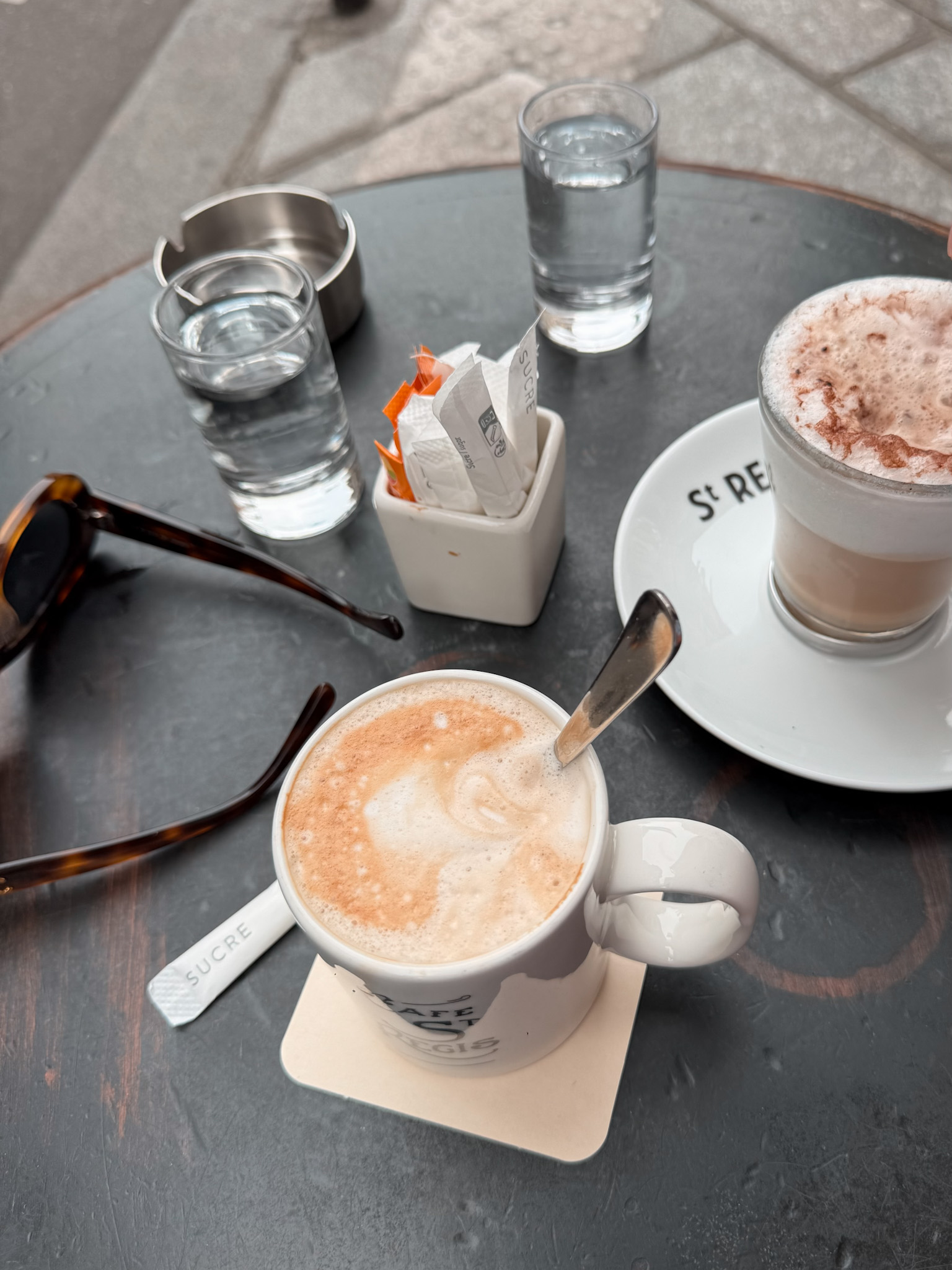 two coffees sitting on a table in Paris.