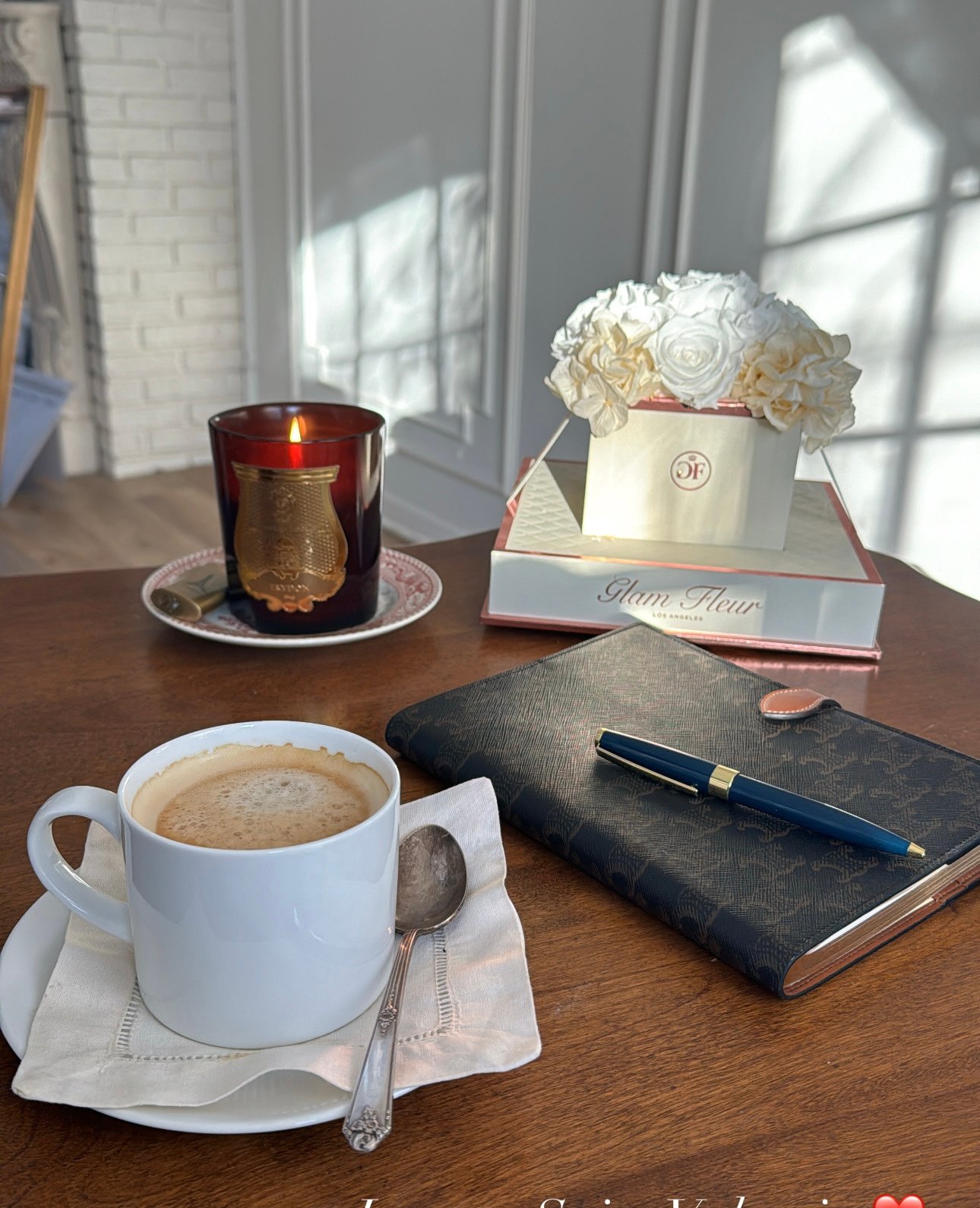 coffee sitting on a table with flowers in the background.