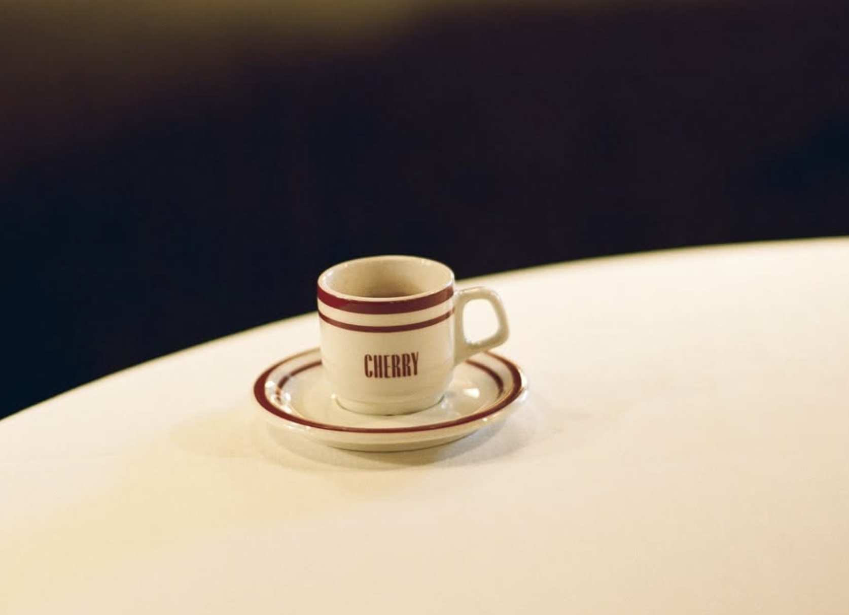 espresso cup of cherry sitting on a table.