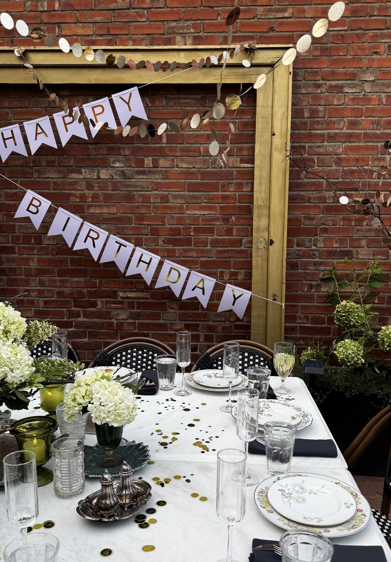 Flowers sitting on a table with a happy birthday sign in the background.