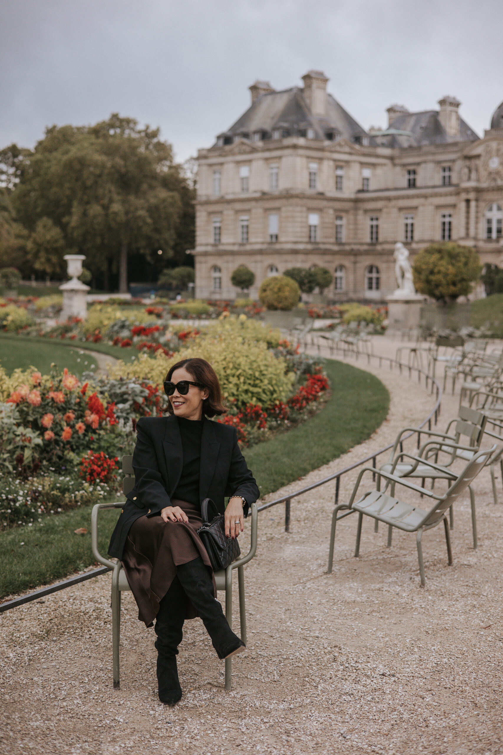 Woman sitting in Luxembourg gardens in fall. 