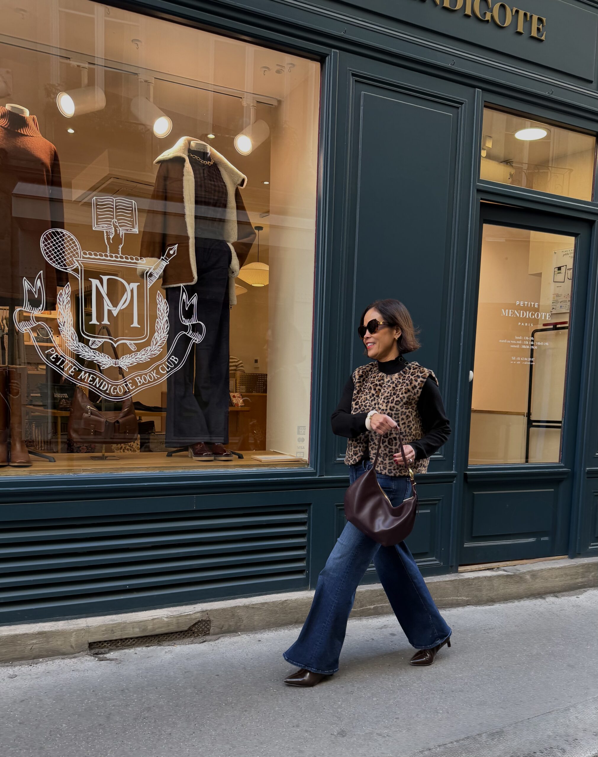 Woman walking in Paris in animalprint vest in the fall.