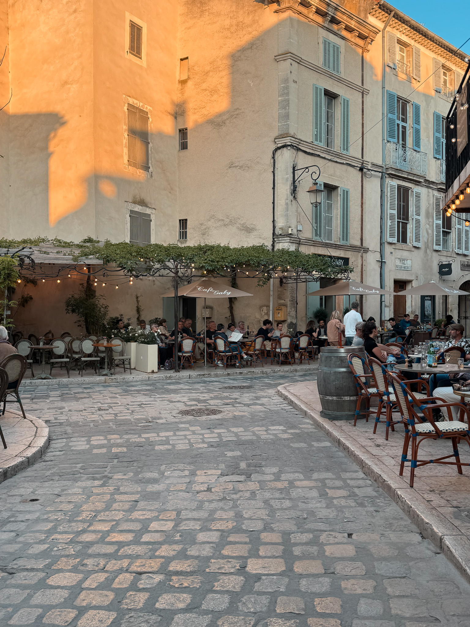 Café-lined village square in Lourmarin with outdoor dining and historic buildings in Provence