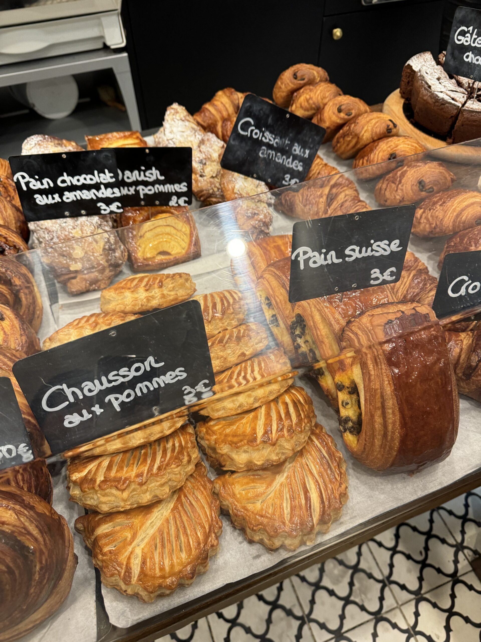 Binome boulangerie in saint germain with croissants and aux pommes sitting on the counter.