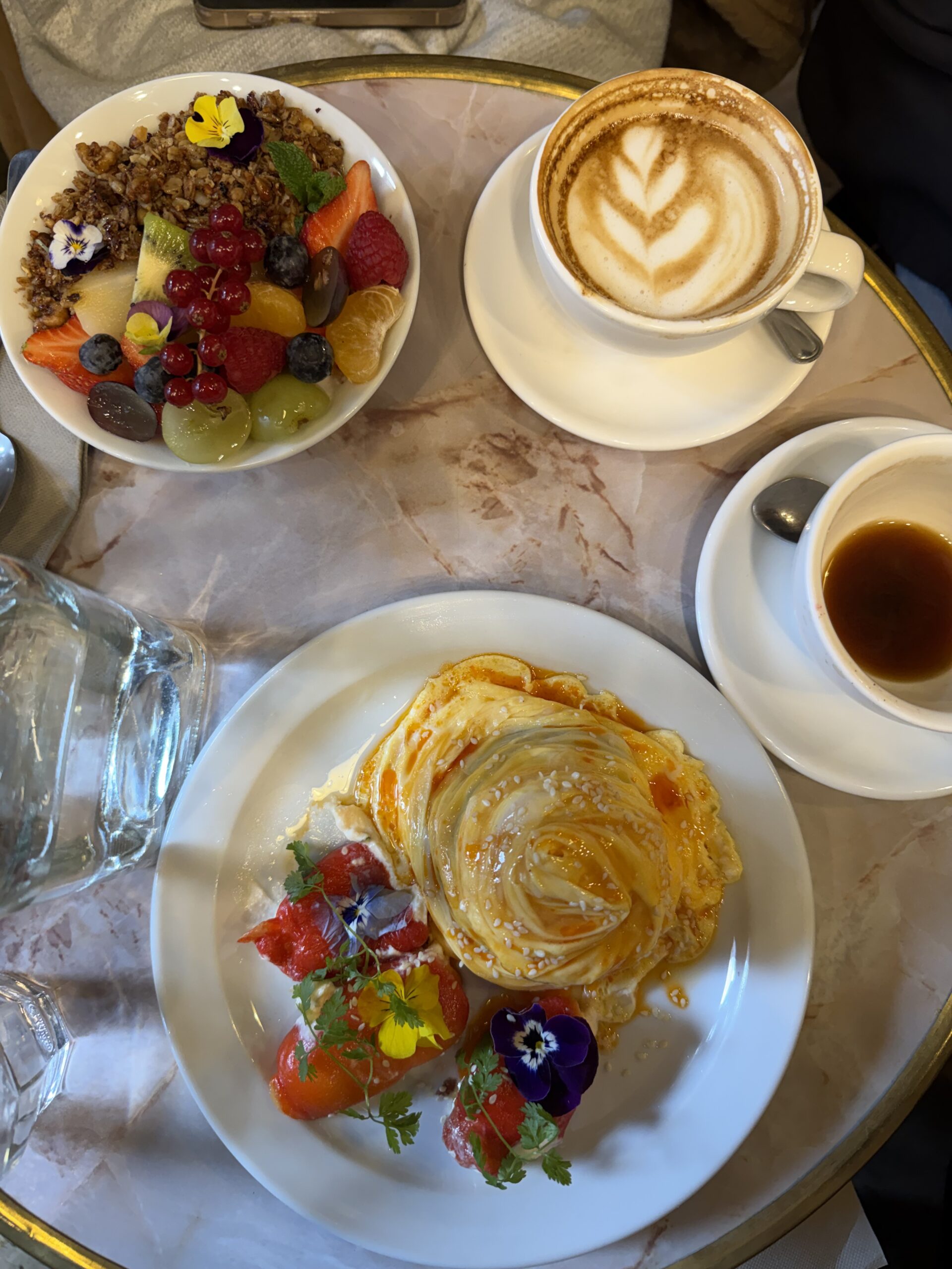 Breakfast spread with pastries, coffee, and fruit served at Saint Pearl café in Paris.