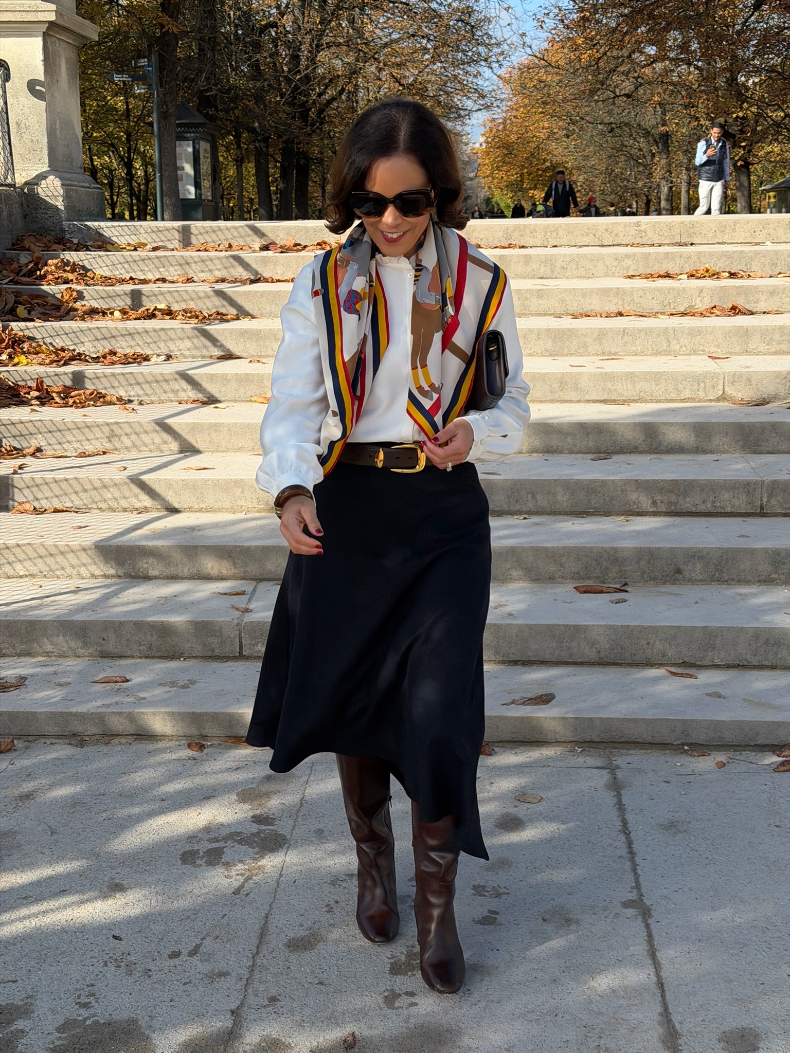 French spring wardrobe outfit with silk scarf, white blouse, and midi skirt styled in Parisian fashion