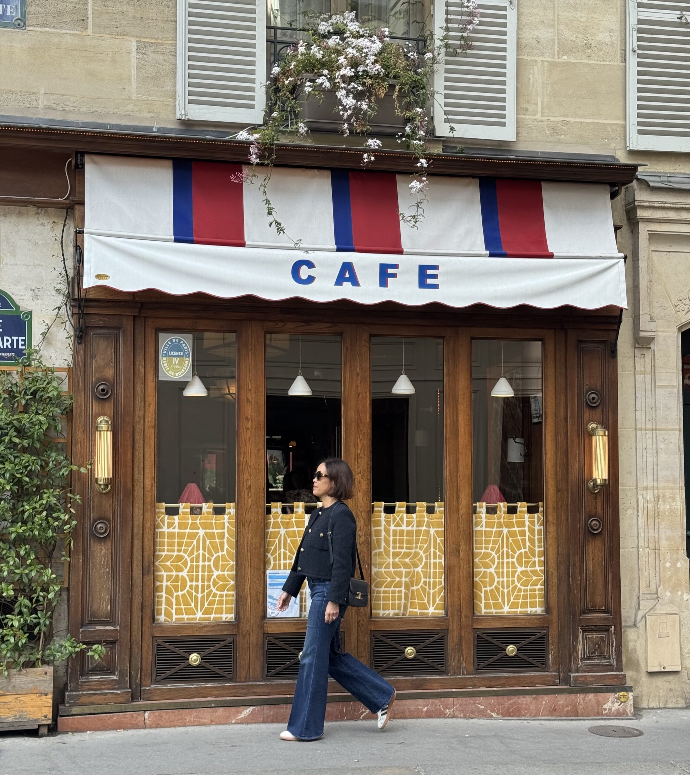 Exterior of Le Bonaparte café in Saint-Germain-des-Prés with classic striped awning and Parisian charm.