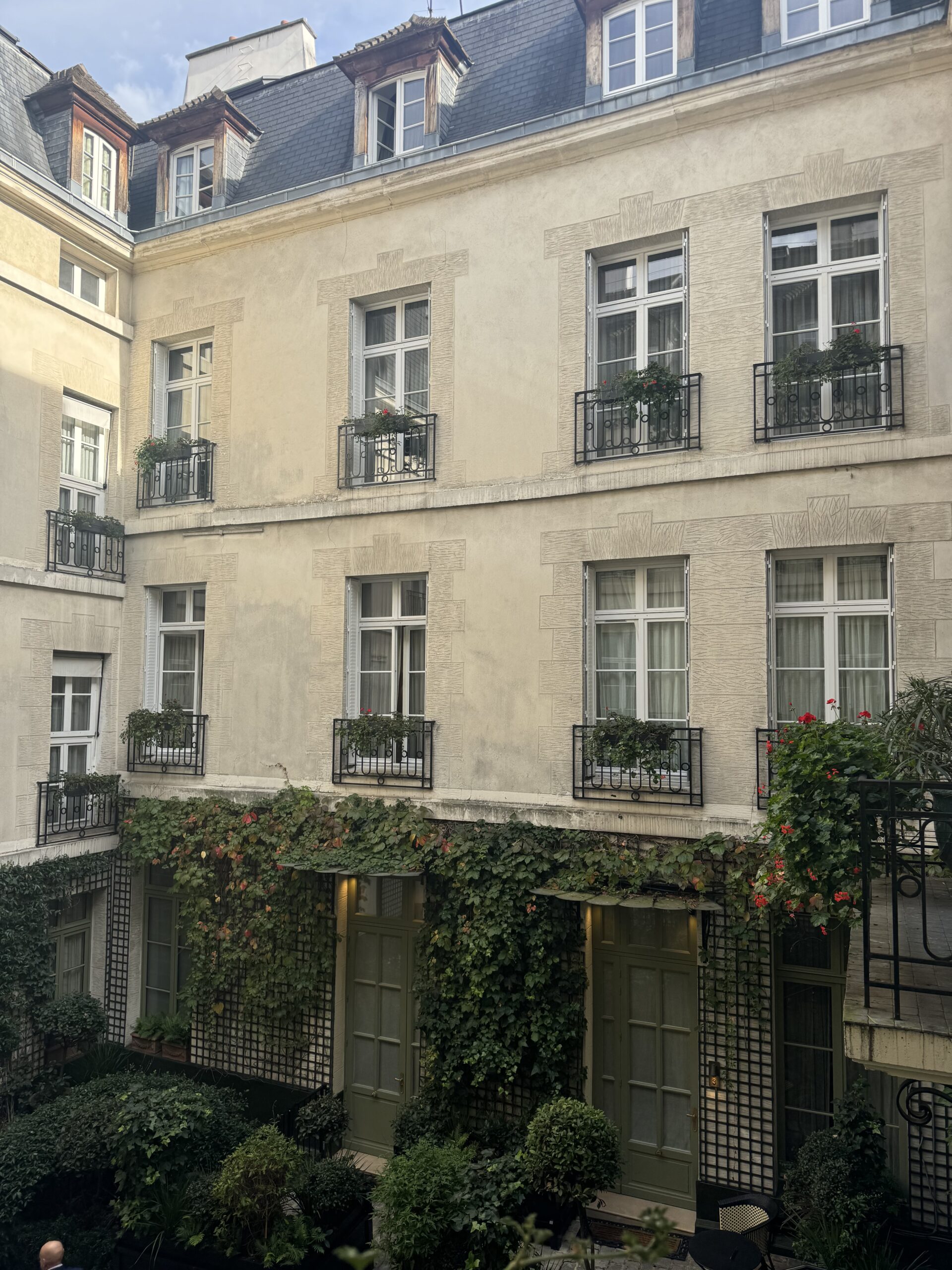 Courtyard view at Relais Christine hotel in Saint-Germain-des-Prés with ivy-covered walls, classic Parisian windows, and private garden setting