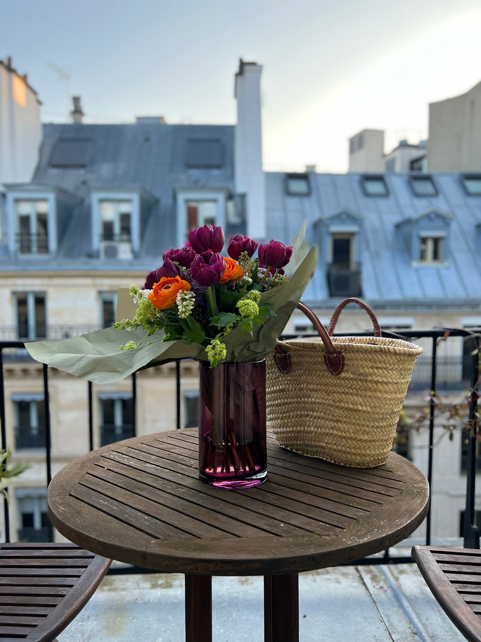 Paris in May — spring flowers and a straw market basket on a Paris rooftop terrace