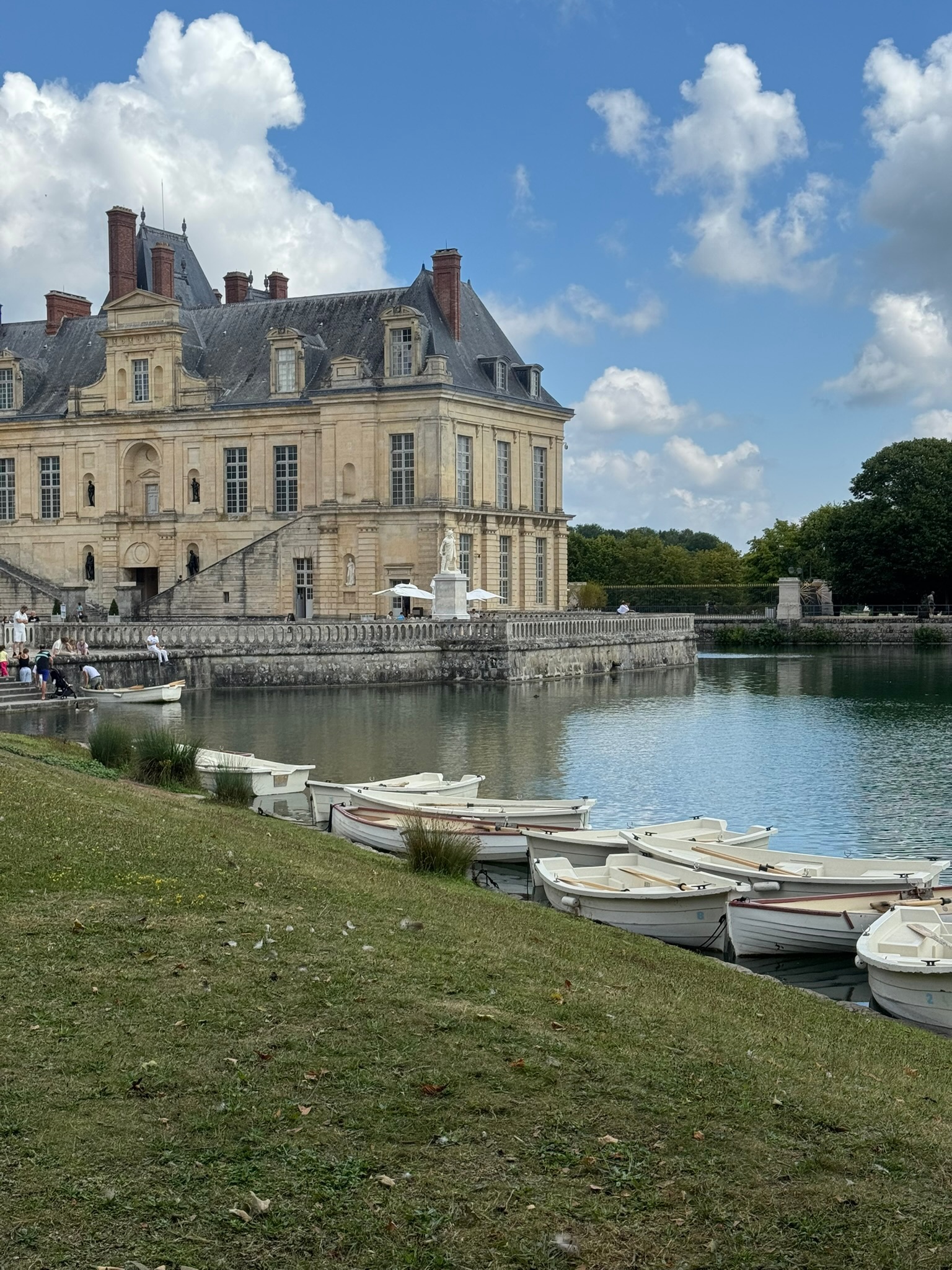 Château de Fontainebleau with rowboats on the pond — best day trip from Paris in summer