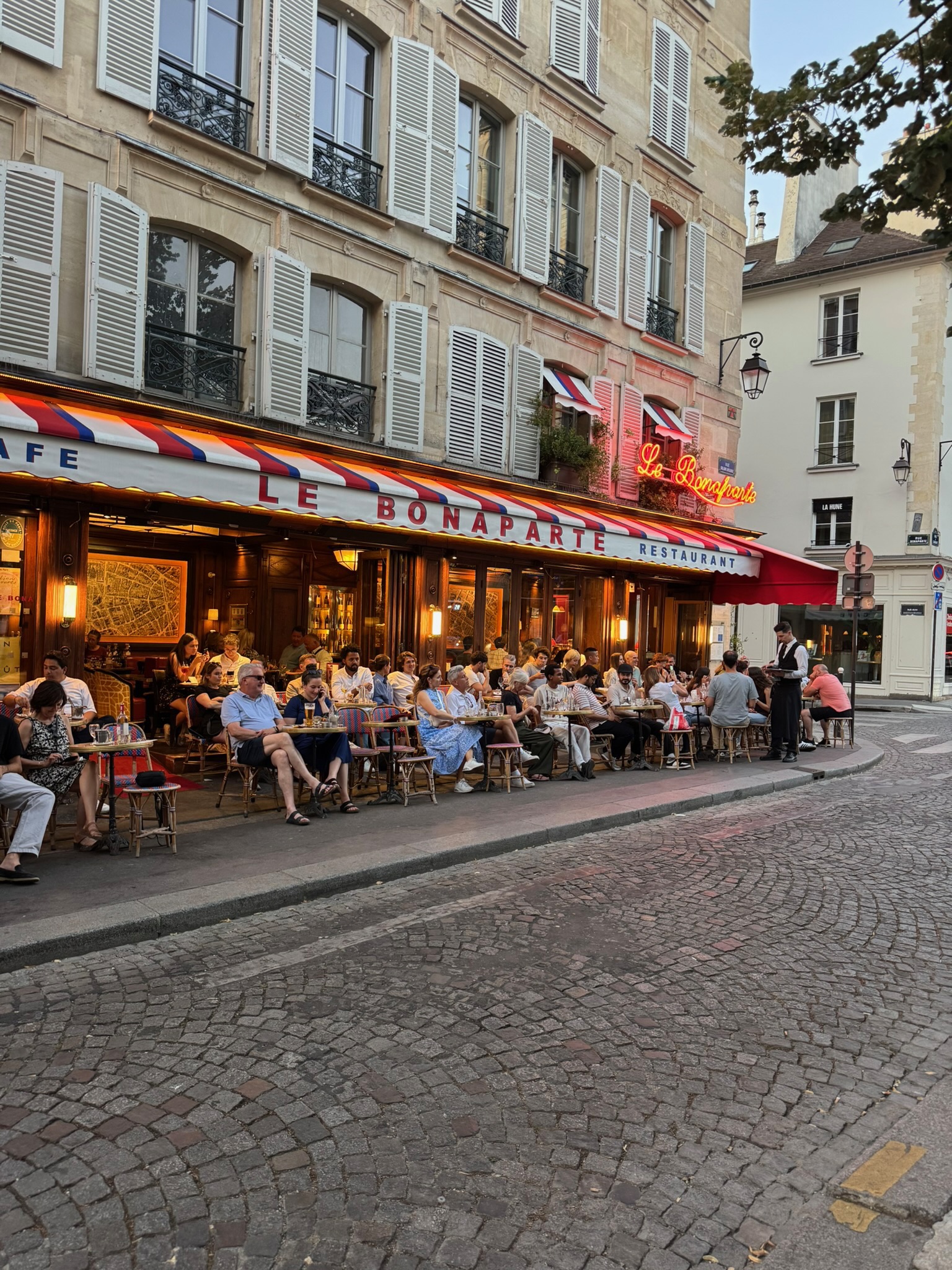 Paris café terrace in summer — people watching at Le Bonaparte in Saint-Germain.