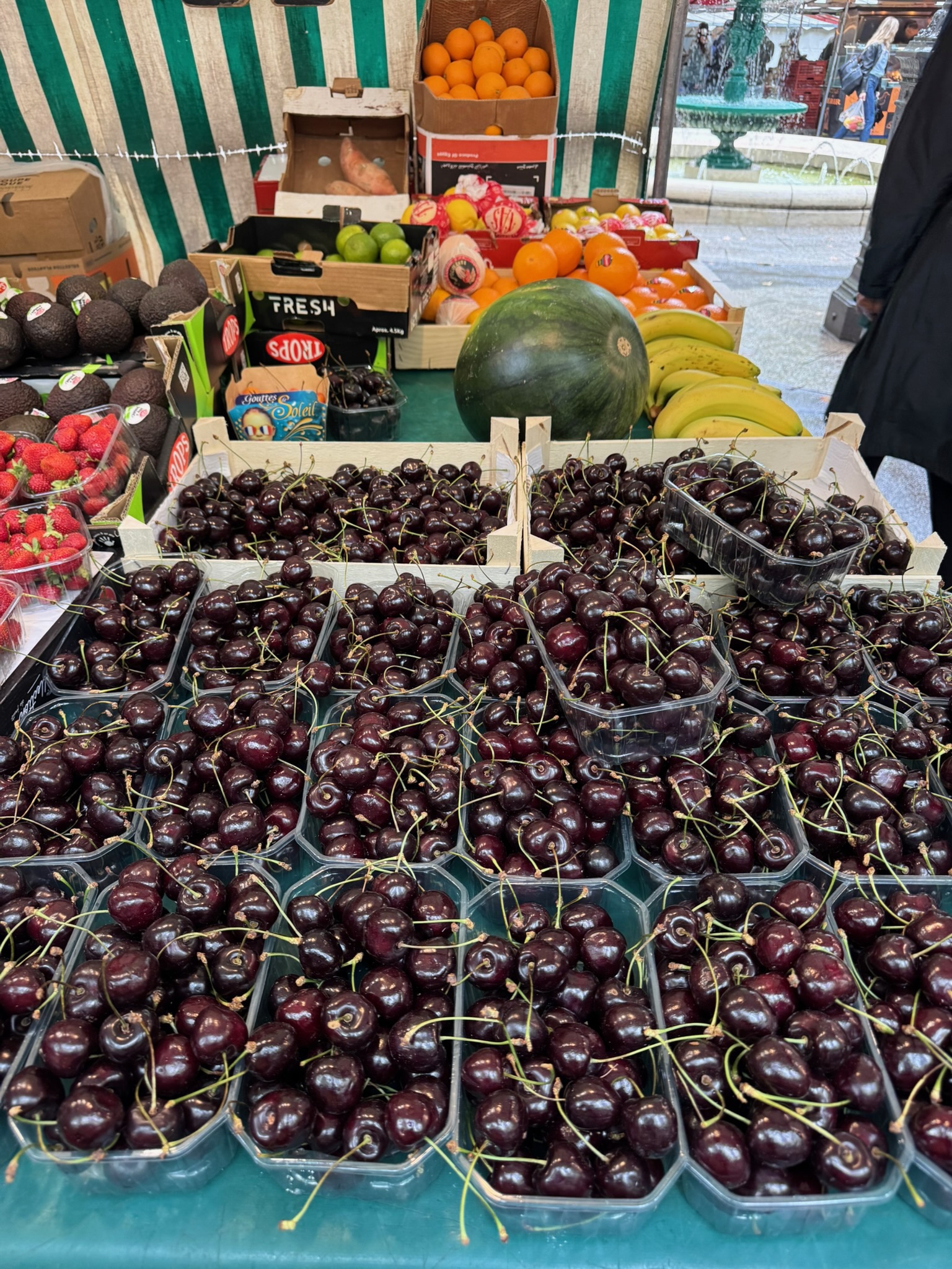dark ripe cherries piled high at a Paris farmers market in summer